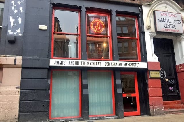 Vibrant bar façade with red accents, ideal for events and workshops in Manchester.