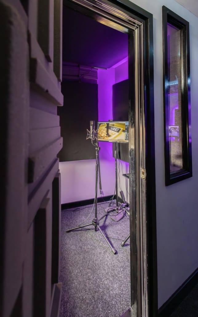 Modern recording studio booth with audio gear for corporate events and podcasts.