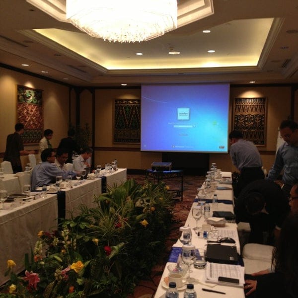 Conference setup at Shangri-La Hotel Jakarta with projector screen and inviting decor.
