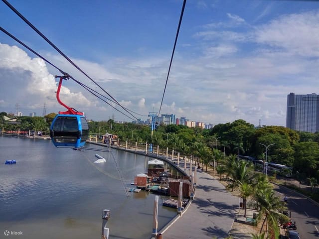 Gondola Ancol amusement park ride over water with urban skyline, perfect for unique events.