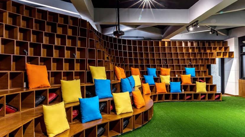 Tiered seating meeting room with colorful cushions at Sewa Office Space for workshops.