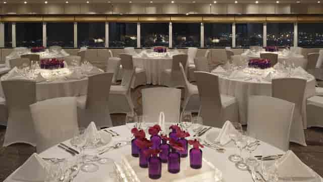 Gulf Auditorium in Dubai Opera, elegant dinner setup with purple centerpieces, corporate events.