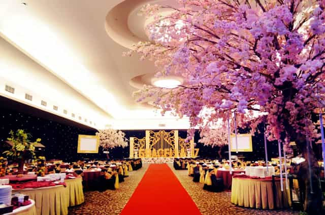 "Elegant gala event space with red carpet and cherry blossoms at Royal Palm Hotel."