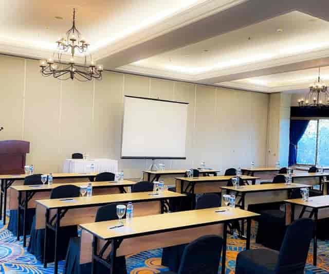 Ballroom in Toeti Roosseno Plaza set up for training sessions with projector and tables.