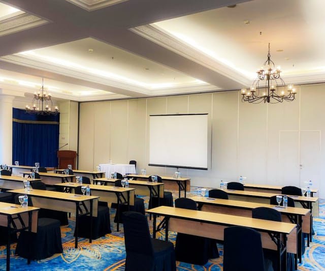 Auditorium in Toeti Roosseno Plaza, conference room with projector and elegant chandeliers.