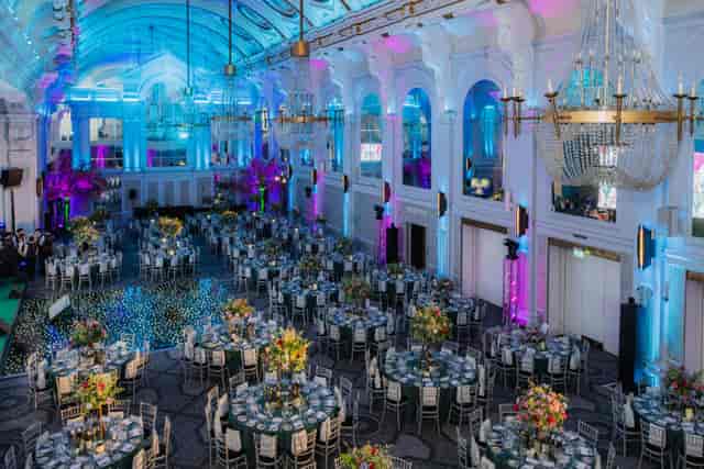 Grand Connaught Rooms gala ballroom with circular banquet seating and vibrant lighting.
