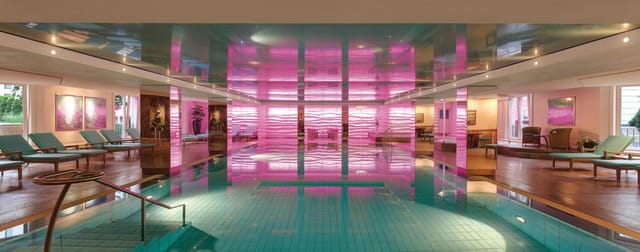 Stylish indoor pool with pink lighting at Europa, Grand Elysée Hamburg for elegant events.