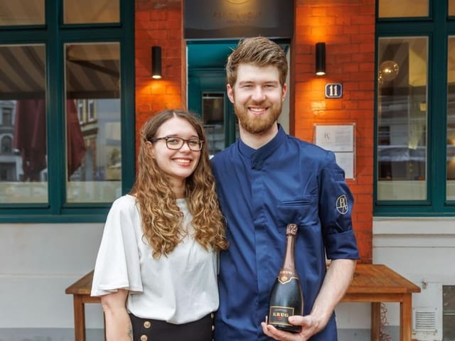 Chef and partner outside Petit Amour restaurant, showcasing hospitality and event venue charm.