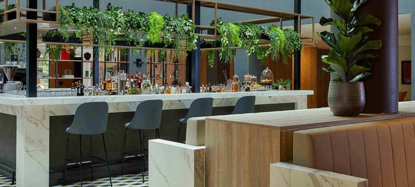Stylish bar area at Crowne Plaza Hamburg for networking events with modern seating and greenery.