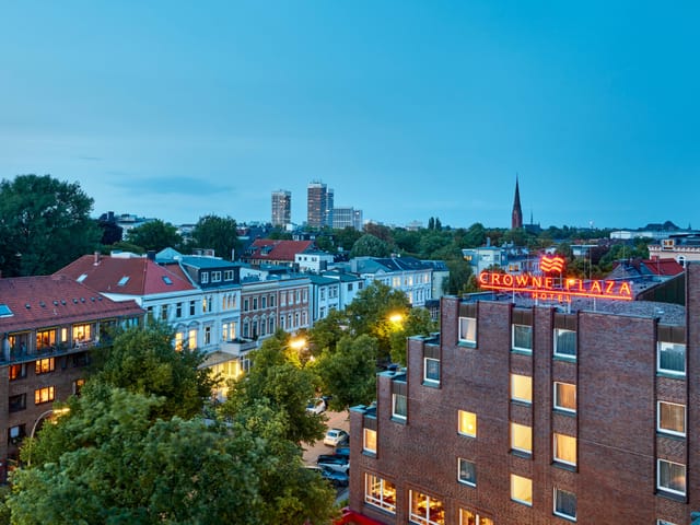 Crowne Plaza Hamburg's Forum, a vibrant meeting venue with greenery backdrop.