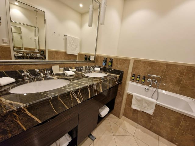 Elegant hotel bathroom with marble dual sinks at Atlantic Hamburg for business events.