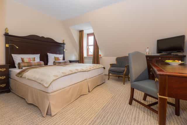 Elegant hotel suite with inviting bed, ideal for meetings and events.