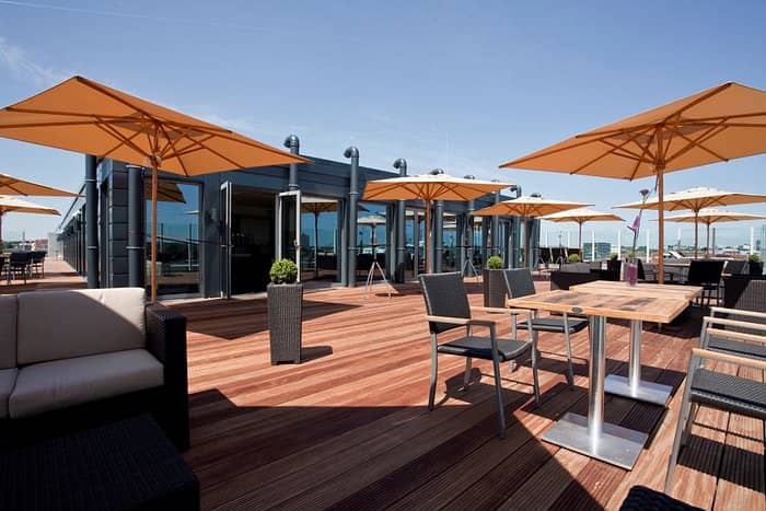 Spacious rooftop bar at Atlantic Hotel Kiel with modern decor for summer events.