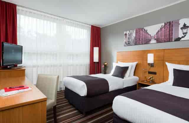 Hotel room with twin beds, ideal for conferences and events in Hamburg.