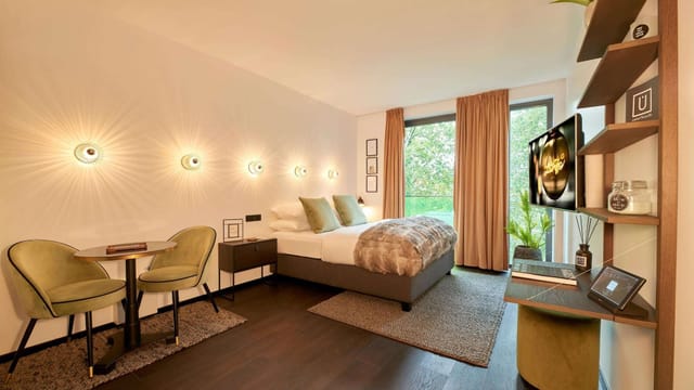 Contemporary hotel room at Designhotel ÜberFluss for business travelers, bright workspace.
