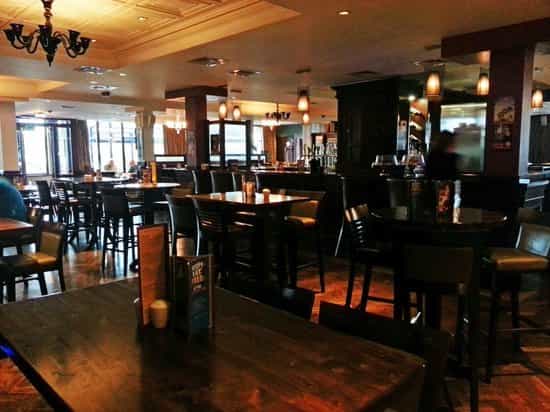 Spacious event venue at Red Cow Moran Hotel with inviting wooden seating and warm lighting.