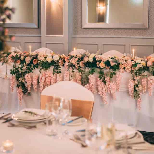 Elegant wedding head table with pink roses and candlelight at Parkview Hotel.