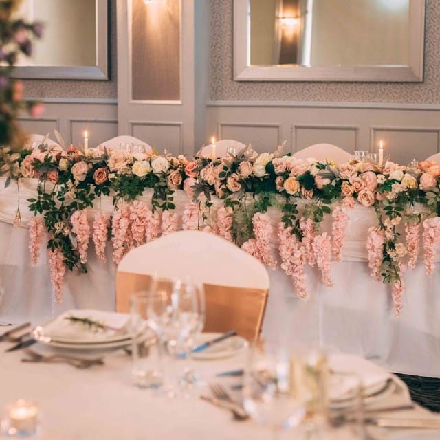 Elegant wedding head table with pink roses and candlelight at Parkview Hotel.