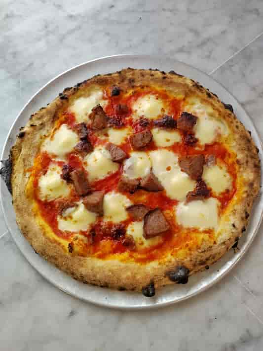 Artisanal pizza with charred crust at The Pizza Shed, ideal for networking events.
