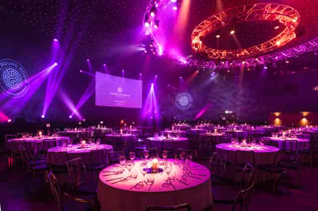 Elegant gala setup in Glass Room Suites with circular tables and vibrant lighting.
