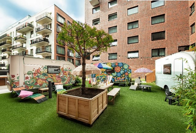 Hafenbühne at Pierdrei, vibrant outdoor event space with colorful trailers and turf.