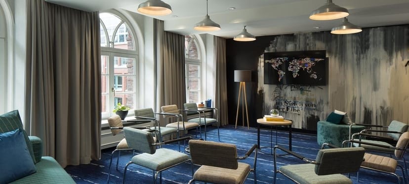 Modern meeting space in Renaissance Hamburg Hotel with natural light and world map artwork.