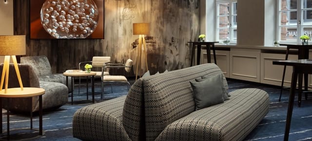 Stylish meeting space with curved sofa at Renaissance Hamburg Hotel for events and networking.