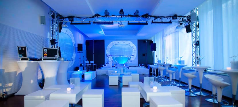 Sleek event space with white furniture and blue lighting for modern gatherings