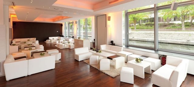 Modern lounge with white furniture, ideal for networking and cocktail events.