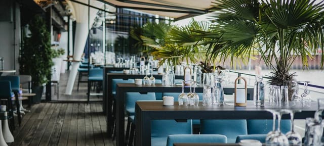 Waterfront terrace event, lush greenery, cocktail reception, corporate event.