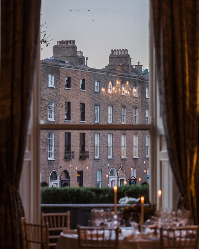 Fine dining restaurant window view, cozy chandeliers, intimate event space in Dublin.