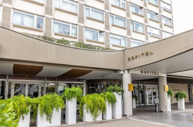Modern Sofitel Lyon Bellecour entrance, elegant greenery, ideal for corporate events.