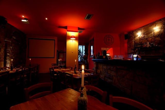 Private dining event, intimate red-lit restaurant, brick, cocktails