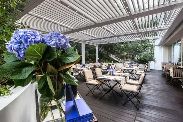 DA NOI IN Restaurant outdoor dining area with blue hydrangeas, ideal for events and gatherings.