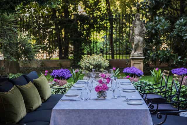 Elegant outdoor dining at Palazzo Parigi's lush garden, perfect for upscale events.