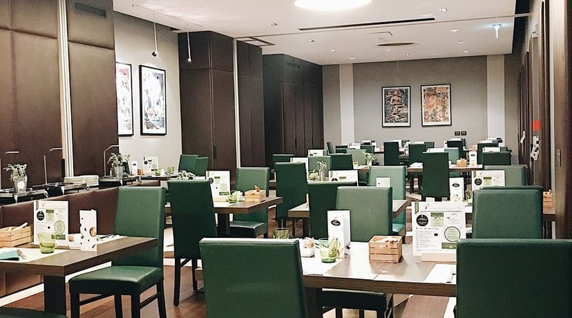 Manin Hotel event space, neutral tones, green accents, corporate lunch, seated dinner