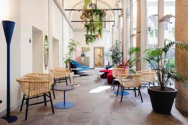 Modern lounge at Hotel Indigo Milan with greenery, ideal for networking events.