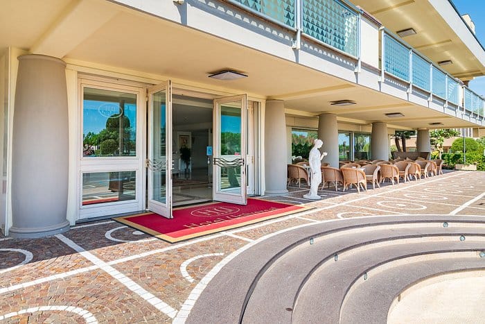 Wellness area entrance at Hotel Universal with polished glass doors and red carpet.