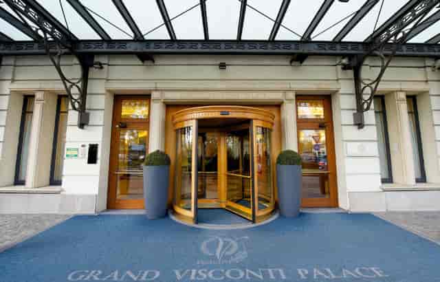 Elegant entrance of Grand Visconti Palace, featuring a stylish revolving door for corporate events.