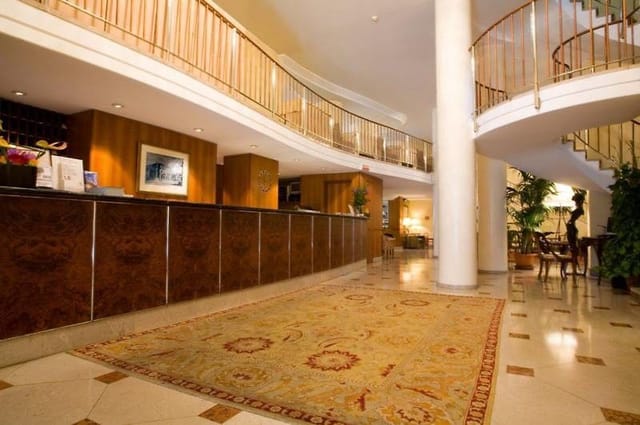 Elegant Hotel Cavour lobby with polished wood, ideal for networking events.