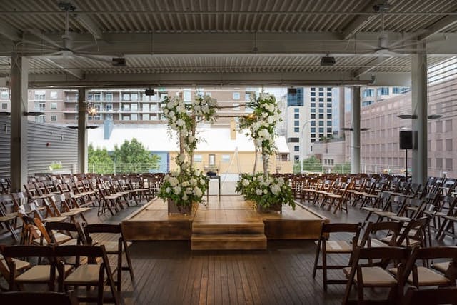 Brazos Hall wedding stage with floral arch, outdoor ceremony venue
