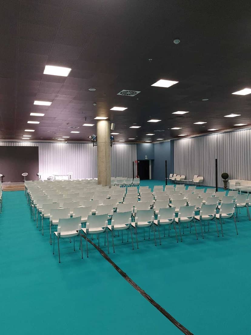 Oriental Room at IFEMA MADRID with white chairs and turquoise carpet for seminars