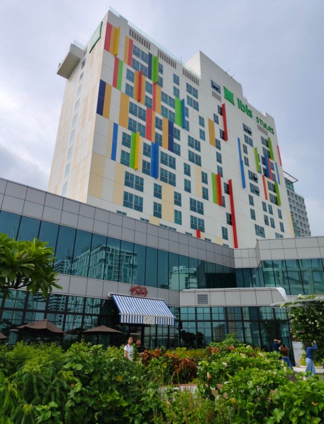 Modern ibis Styles Manila hotel, vibrant facade, family event, conference venue.