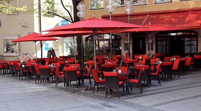 Red parasols at Andechser am Dom for casual networking event and outdoor luncheon.