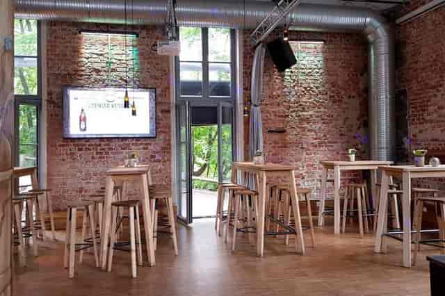 Schänke at Giesinger Bräu: Industrial-chic event space with high-top tables for networking mixers.