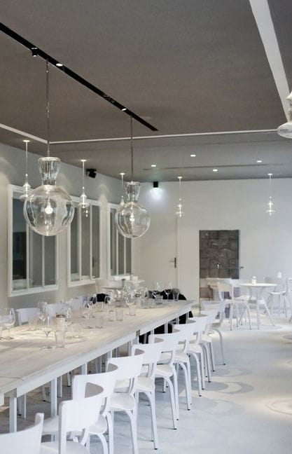 Orangerie at Café Reitschule: Minimalist private dining room with pendant lighting for events.
