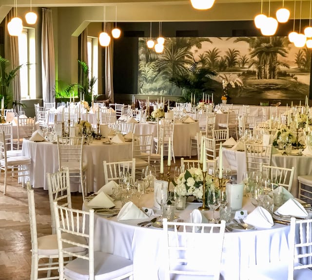 Elegant gala setup at Studio OG Café Reitschule with mural backdrop for corporate event planning.