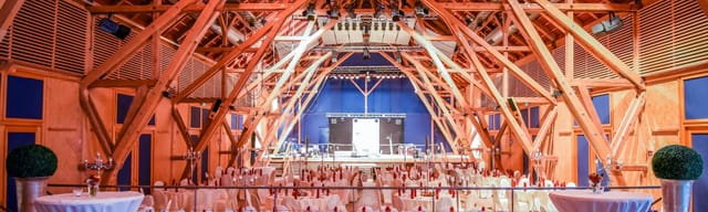Florian-Stadl Kloster Andechs: rustic barn with gala stage lighting for corporate events.
