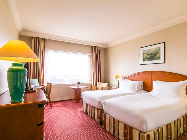 Pullman Bucharest hotel twin room with workspace for conference breakouts and business meetings.