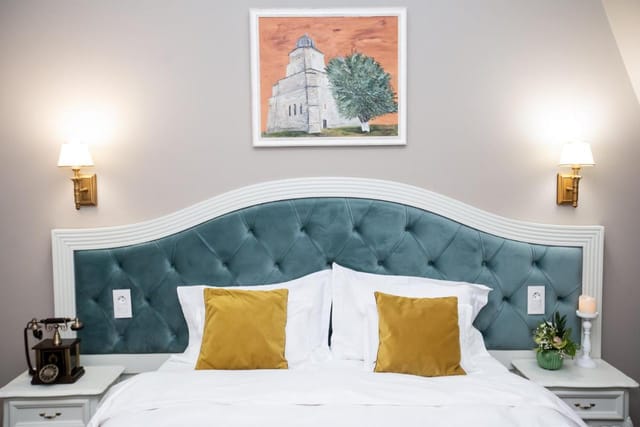 Boutique hotel room with teal tufted headboard for luxury corporate events and VIP retreats.